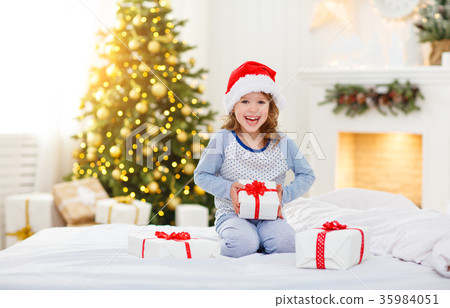 happy child girl with gifts in bed on Christmas morning. happy child girl with gifts in bed on Christmas morning. 35984051