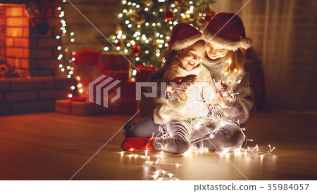 Merry Christmas! mother and child daughter with glowing garland Merry Christmas! mother and child daughter with glowing garland 35984057