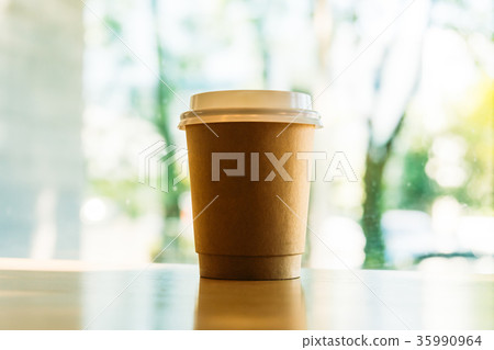 Hot latte coffee in paper cup on table in cafe 35990964