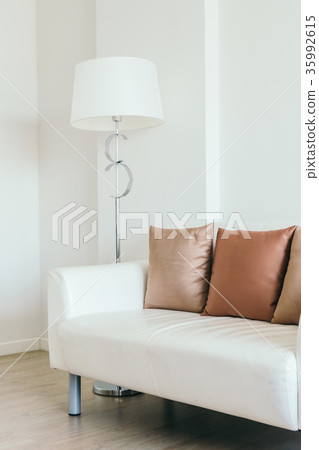 Comfortable pillow on white sofa with light lamp Comfortable pillow on white sofa with light lamp 35992615