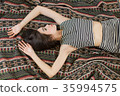 Asian girl is lie down on the rug. 35994575