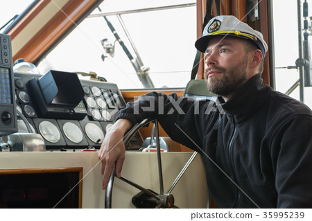 Captain at the helm of boat going along the Captain at the helm of boat going along the 35995239