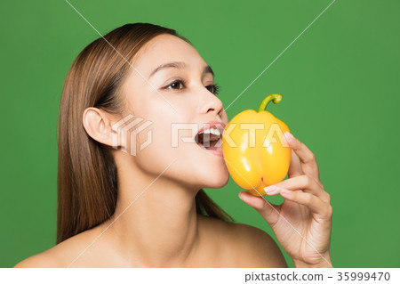 A woman gnawing paprika A woman gnawing paprika 35999470