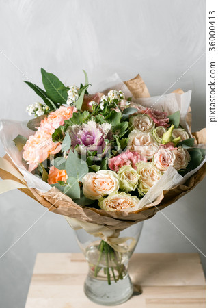 beautiful bouquet of mixed flowers into a vase on 36000413