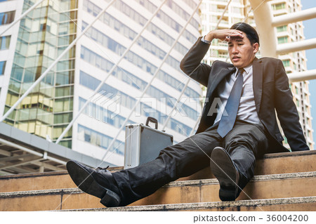 Desperate businessman sitting hopelessly on stair floor 36004200