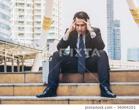 Desperate businessman sitting hopelessly on stair floor 36004201