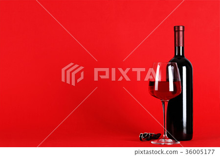 a bottle of wine and a glass on a red background a bottle of wine and a glass on a red background 36005177