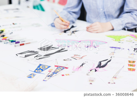 Young designer draws sketches of clothes. Young designer draws sketches of clothes. 36008646