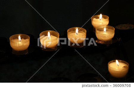 White candles burning in dark church close up White candles burning in dark church close up 36009708