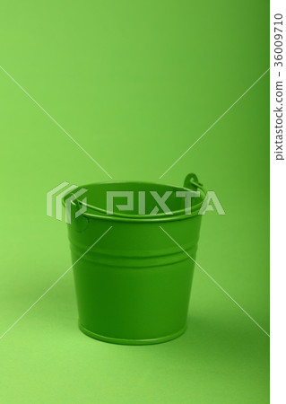 Small metal bucket on green background close up Small metal bucket on green background close up 36009710