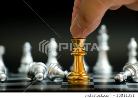 Businessman hold gold king with pawn lay down Businessman hold gold king with pawn lay down 36011351