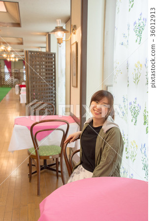 一個女人坐在一家餐廳（日本經濟大學 36012913