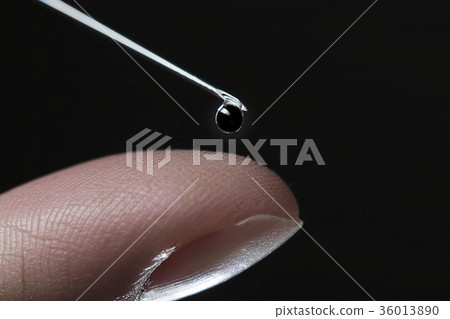 Drip drop on needle of syringe and finger 36013890