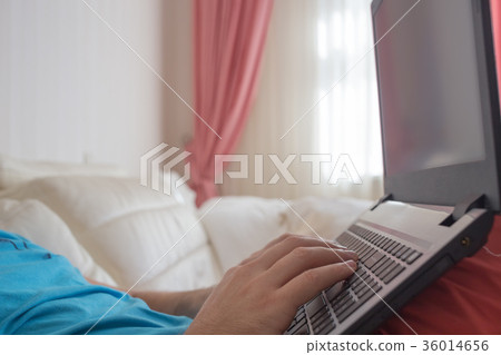 Man's hands typing on laptop notebook keyboard at 36014656