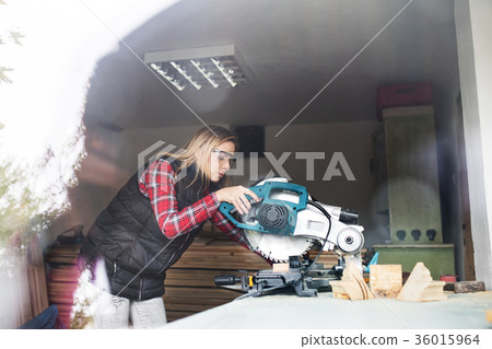 Young woman worker in the carpenter workroom. Young woman worker in the carpenter workroom. 36015964