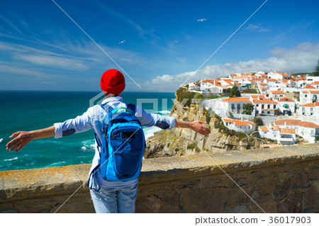 Woman enjoys a view of the ocean coast Woman enjoys a view of the ocean coast 36017903