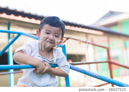 Asian boy hang the metal bar at playground. Asian boy hang the metal bar at playground. 36027525