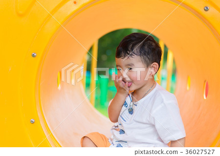 Cute Asian boy playing smiling in yellow tunnel Cute Asian boy playing smiling in yellow tunnel 36027527