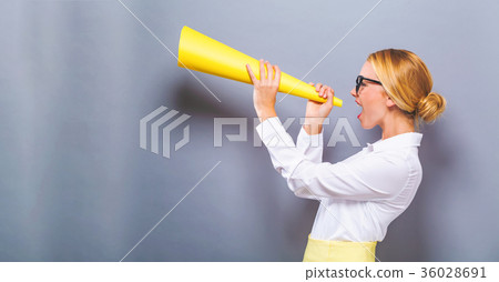 Young woman holding a paper megaphone Young woman holding a paper megaphone 36028691