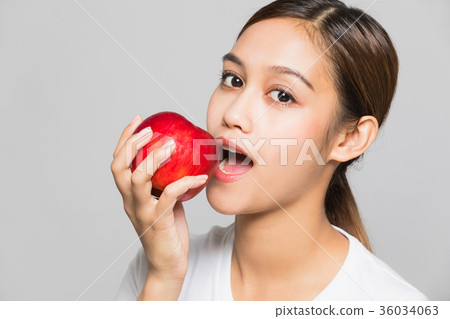 A woman gnawing an apple A woman gnawing an apple 36034063