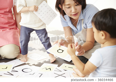 Nursery teacher and children studying 36034466