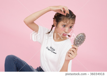 A woman looking at a mirror A woman looking at a mirror 36034918