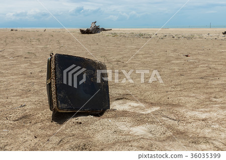 The old television remains were left on the beach. 36035399