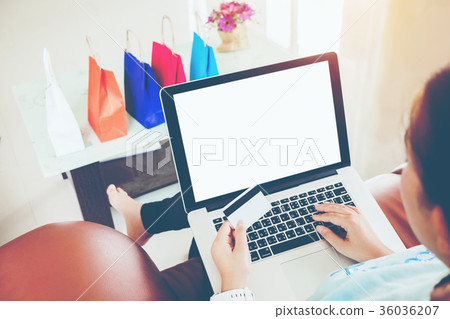 Woman shopping online using laptop blank screen 36036207