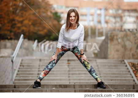 Sporty girl doing gymnastic exercise in city park 36036895
