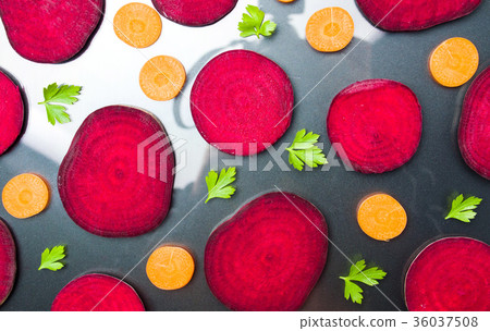 Raw beet and carrot slices isolated on dark Raw beet and carrot slices isolated on dark 36037508