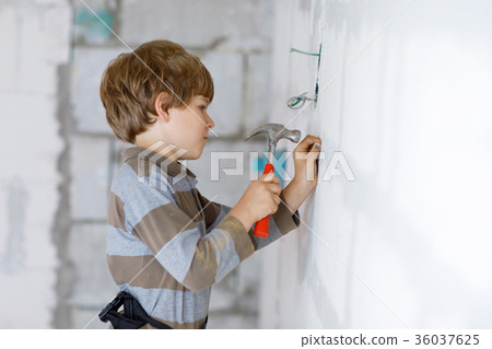 Little kid boy helping with toy tools on Little kid boy helping with toy tools on 36037625