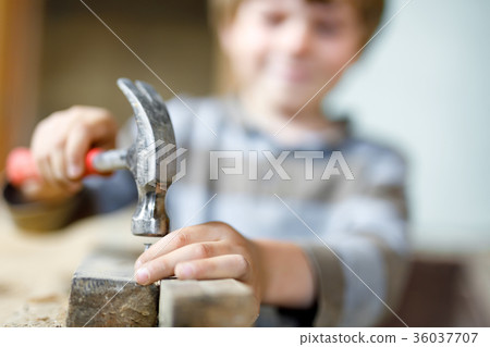 Little kid boy helping with toy tools on Little kid boy helping with toy tools on 36037707
