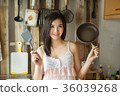 Smile Asian girl in is holding pan the kitchen.  36039268