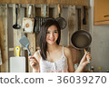 Smile Asian girl in is holding pan the kitchen.  36039270