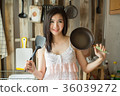 Smile Asian girl in is holding pan the kitchen.  36039272