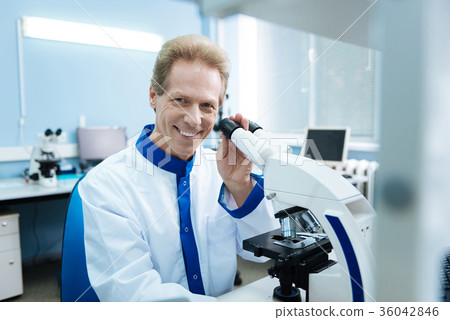 Content researcher with a microscope in the lab Content researcher with a microscope in the lab 36042846