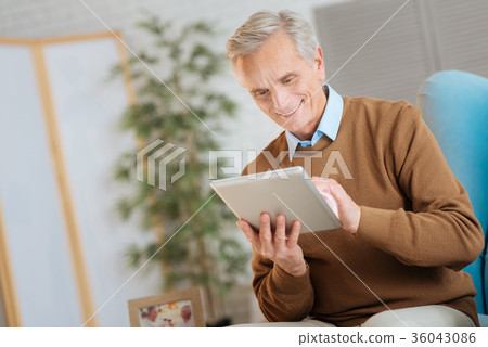 Relaxed old gentleman working on touchpad and Relaxed old gentleman working on touchpad and 36043086