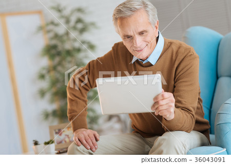 Joyful senior man smiling while looking at Joyful senior man smiling while looking at 36043091
