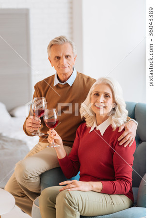 Joyful retired couple enjoying their glasses off 36043389