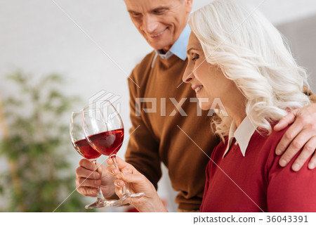 Cheerful married couple drinking red wine Cheerful married couple drinking red wine 36043391