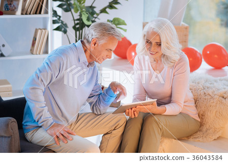 Relaxed elderly couple in casual watching videos Relaxed elderly couple in casual watching videos 36043584