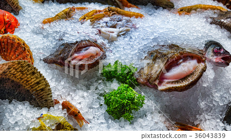 Fresh different fish on ice in a supermarket.  36043839