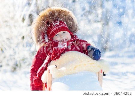 Sled and snow fun for kids. Baby sledding in park. Sled and snow fun for kids. Baby sledding in park. 36044292