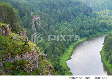 Man backpacker practicing yoga warrior pose on 36046848