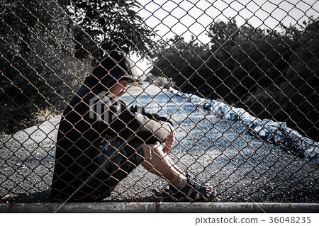 Depressed man wearing hoodie sitting on the ground Depressed man wearing hoodie sitting on the ground 36048235