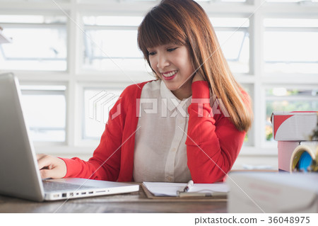 startup small business owner working with computer at workplace. freelance woman seller check product order to prepare for delivery to customer. Online selling, e-commerce, shipping concept startup small business owner working with computer at workplace. freelance woman seller check product order to prepare for delivery to customer. Online selling, e-commerce, shipping concept 36048975