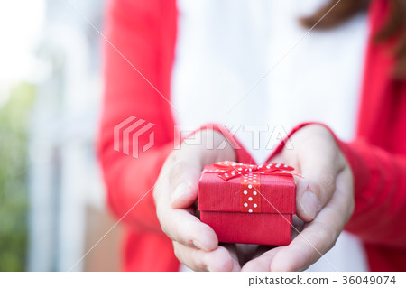 woman holding gift box. asian female wear white shirt and red knitting cardigan with present box. christmas, new year, birthday, valentine, celebration concept. 36049074