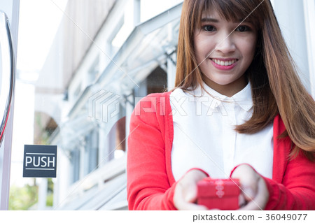 woman holding gift box. asian female wear white shirt and red knitting cardigan with present box. christmas, new year, birthday, valentine, celebration concept. woman holding gift box. asian female wear white shirt and red knitting cardigan with present box. christmas, new year, birthday, valentine, celebration concept. 36049077