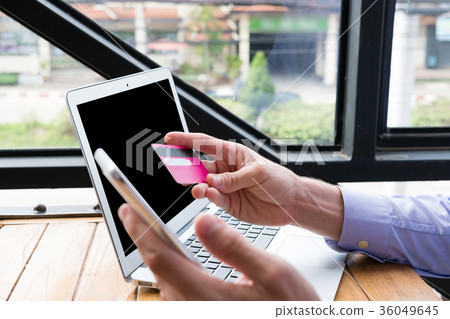 businessman holding credit card & smart phone at office. man purchase goods & make payment on internet by mobile phone. online shopping, banking, paying, lifestyle concept businessman holding credit card & smart phone at office. man purchase goods & make payment on internet by mobile phone. online shopping, banking, paying, lifestyle concept 36049645