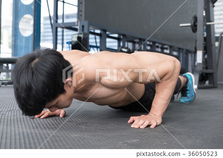 muscle man doing push ups in gym. bodybuilder male working out in fitness center. athlete doing exercises in health club. strength, sport, training, healthy lifestyle concept 36050523
